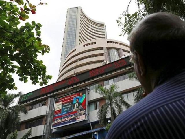 A man looks at a screen across a road displaying the Sensex on the facade of the Bombay Stock Exchange (BSE) building in Mumbai.(Reuters)