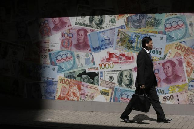 A man walks past a poster showing different countries bank notes in Hong Kong, Friday, June 24, 2016. The British pound is experiencing volatile trading as results from Britain’s vote on European Union membership is tallied. (AP Photo) A man walks past a poster showing different countries bank notes in Hong Kong, Friday, June 24, 2016. The British pound is experiencing volatile trading as results from Britain’s vote on European Union membership is tallied. (AP Photo)