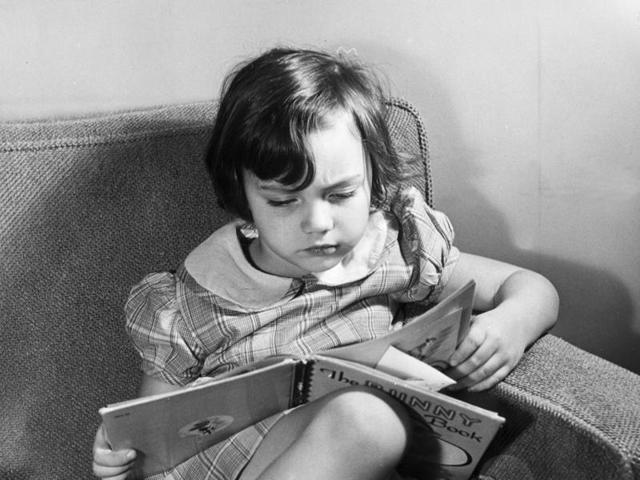 A young girl sits in an armchair, reading a children's book. (Getty Images) A young girl sits in an armchair, reading a children's book. (Getty Images)