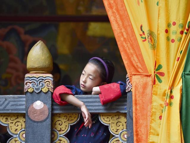 Dressed in traditional Bhutanese attire, a young girl participates in the festivity to celebrate the Guru's birth anniversary at Paro Dzong in Paro. (Gurinder Osan/HT PHOTO)