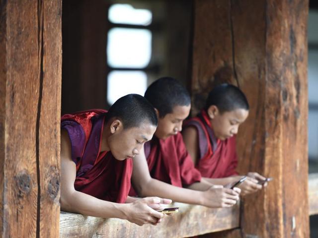 Young monks check their smart phones during celebrations. (Gurinder Osan/HT PHOTO)