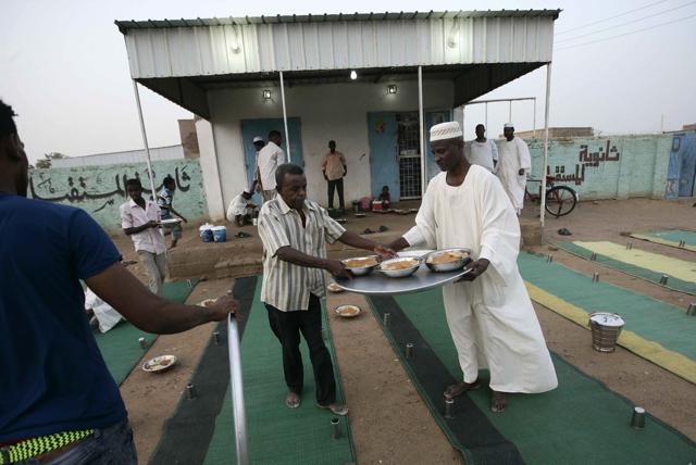 Sudanese men prepare to break the fast with a dinner by the side of the Khartoum highway in the village of al-Nuba. (AFP Photo) Sudanese men prepare to break the fast with a dinner by the side of the Khartoum highway in the village of al-Nuba. (AFP Photo)