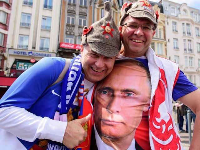 A Russia supporter poses with a fellow fan wearing a t shirt featuring Russian President Vladimir Putin as they walk in central Lille on June 15, 2016 . (AFP Photo) A Russia supporter poses with a fellow fan wearing a t shirt featuring Russian President Vladimir Putin as they walk in central Lille on June 15, 2016 . (AFP Photo)