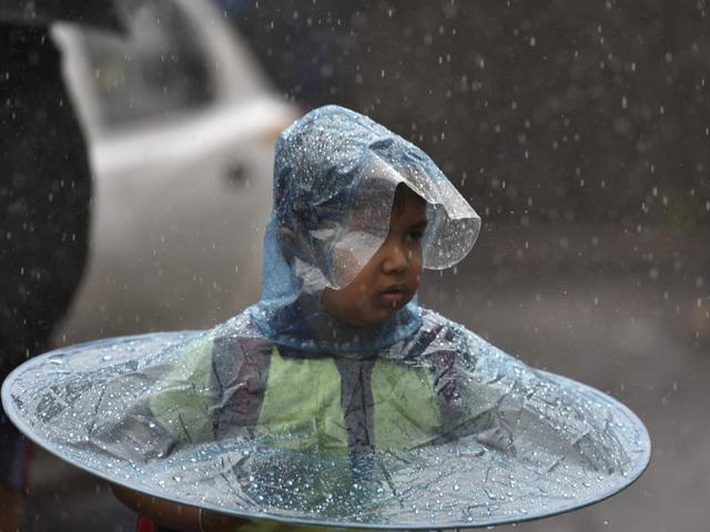 Amid the heavy showers children take all kinds of precautions to deal with the rains. (Arijit Sen)