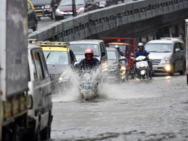 Vehicles wade through a waterlogged area at Parel leading to heavy traffic snarls in the central business hub on Friday. (Vijayanand Gupta)