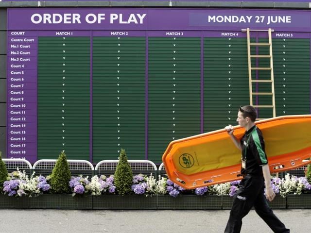A member of staff walks past the order of play board. (AP) A member of staff walks past the order of play board. (AP)