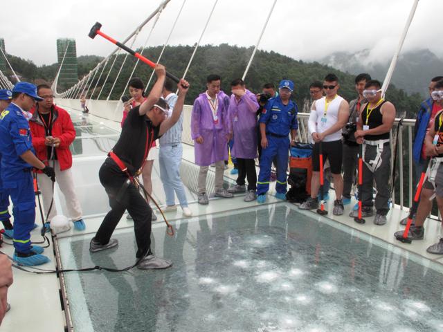 A man strikes a hammer against the glass bridge. (REUTERS) A man strikes a hammer against the glass bridge. (REUTERS)