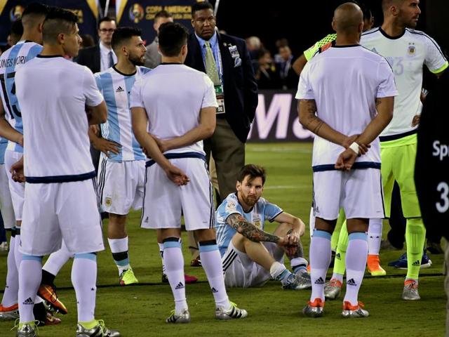 A disconsolate Messi sits down as Argentina wait to receive their runners-up medals. (AFP)