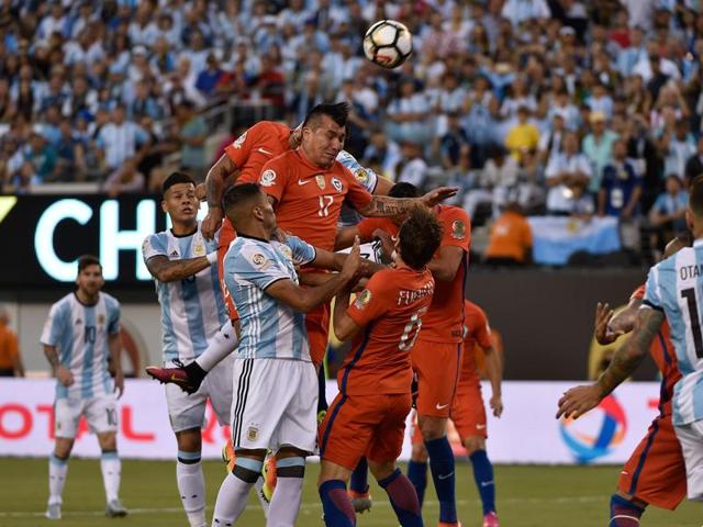 Argentine and Chilean players jump for the ball. (AFP)