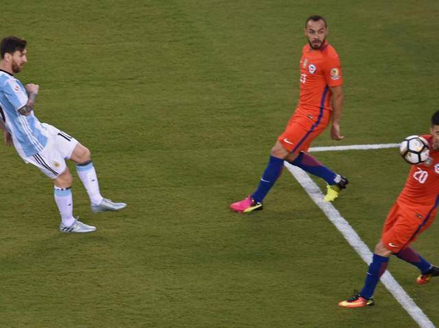 Lionel Messi (L) strikes the ball to hit Chile's Charles Aranguiz on the face. (AFP)