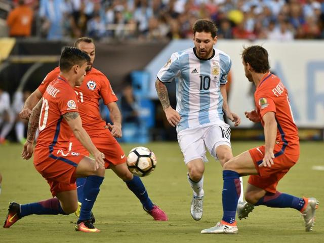 Lionel Messi (#10) steers the ball past three Chilean defenders. (AFP)