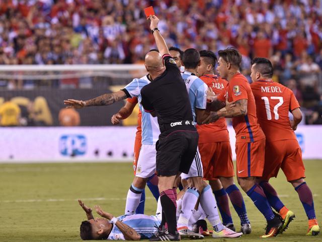 Heber Lopes red cards Argentina's Marcos Rojo (on the ground) for fouling Chile's Arturo Vidal (out of frame). (AFP) Heber Lopes red cards Argentina's Marcos Rojo (on the ground) for fouling Chile's Arturo Vidal (out of frame). (AFP)