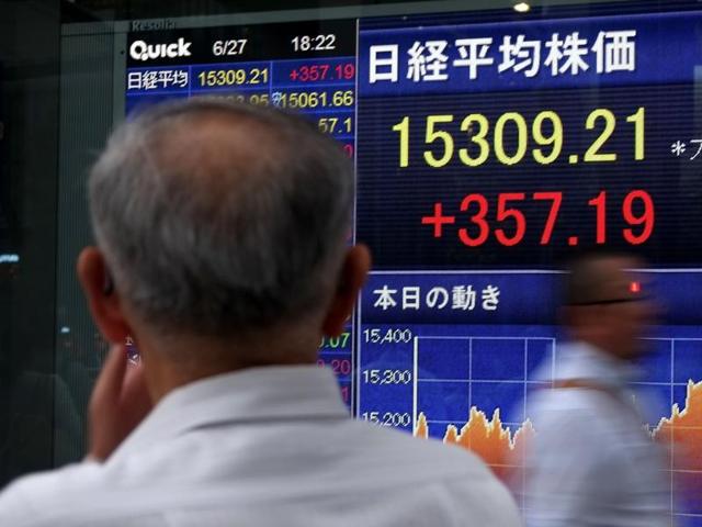 A pedestrian looks at a share prices board showing numbers from the Tokyo Stock Exchange in Tokyo on June 27, 2016. (AFP) A pedestrian looks at a share prices board showing numbers from the Tokyo Stock Exchange in Tokyo on June 27, 2016. (AFP)