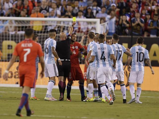 Referee Heber Lopes hands out a yellow card. (Reuters)
