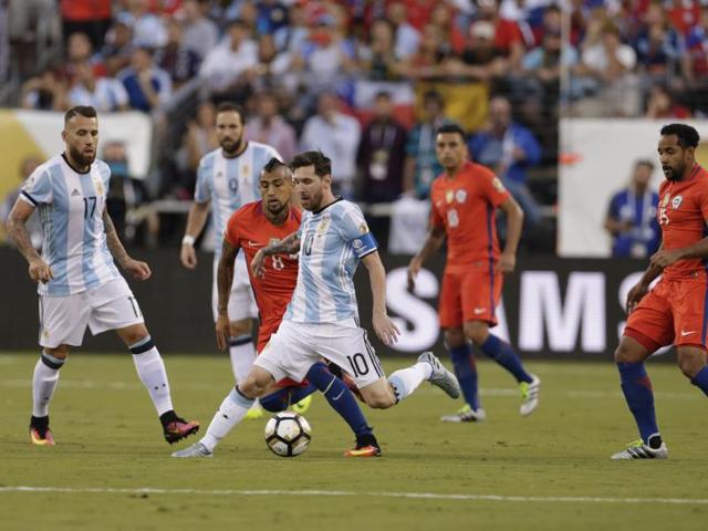 Lionel Messi dribbles the ball past Chile’s Arturo Vidal. (Reuters)