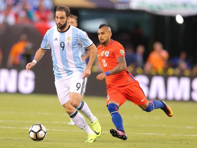 Argentina forward Gonzalo Higuain (9) dribbles the ball past Chile midfielder Arturo Vidal (8). (Reuters)