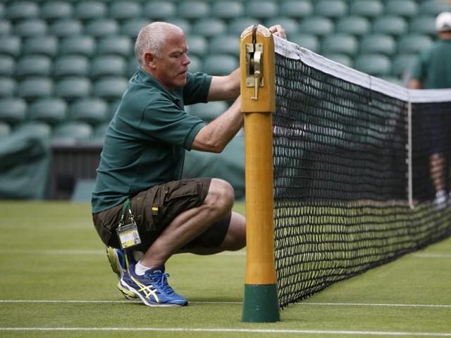 A groundstaff member sets up a net on one of the courts. (REUTERS) A groundstaff member sets up a net on one of the courts. (REUTERS)