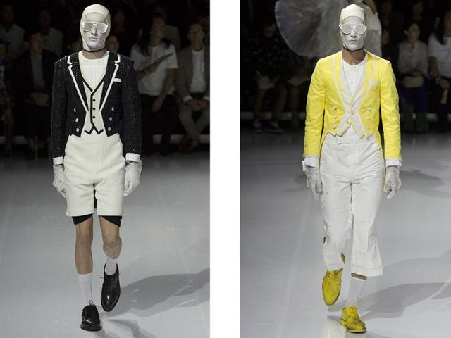 As the models were transitioning from their overcoats to their short suits, several other models appeared, walking around the periphery of the stage with tropical bird and shark masks and feather suits.