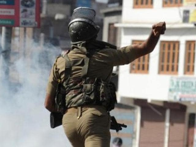 A security personnel throws a rock towards protestors during clashes in Srinagar in April 2015. A turf war between security agencies can hardly help peace in Kashmir.(AFP/Getty Images)