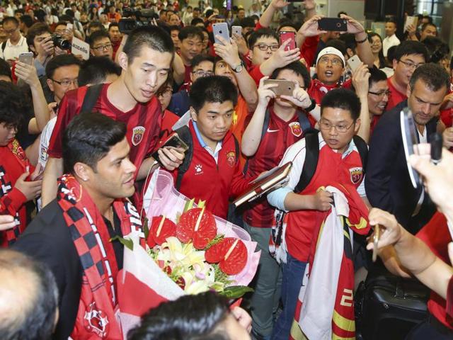 Brazilian football player Hulk (left) is surrounded by excited fans waiting at the airport in Shanghai.(AP Photo)
