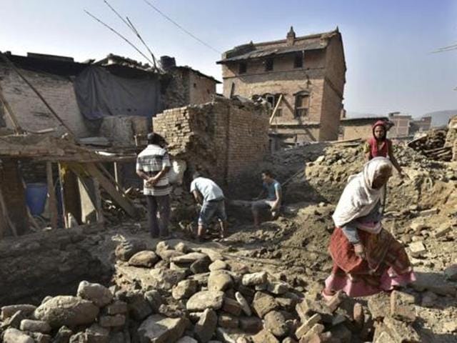 People move through earthquake-damaged houses that continue to be in a bad condition one year after the devastating earthquake in Nepal. (HTi Photo) People move through earthquake-damaged houses that continue to be in a bad condition one year after the devastating earthquake in Nepal. (HTi Photo)
