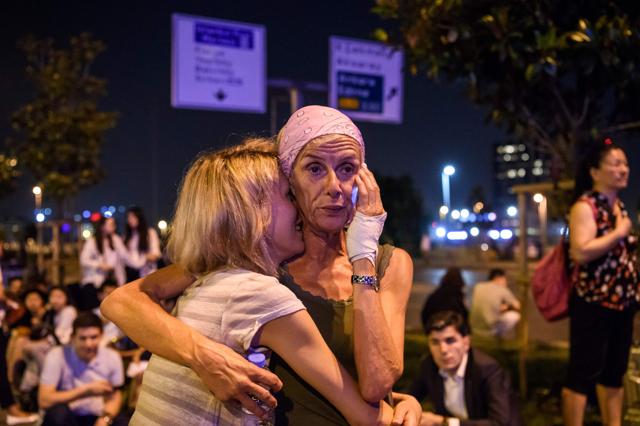 Passengers embrace outside Ataturk airport`s main entrance in Istanbul, on Tuesday. (AFP) Passengers embrace outside Ataturk airport`s main entrance in Istanbul, on Tuesday. (AFP)