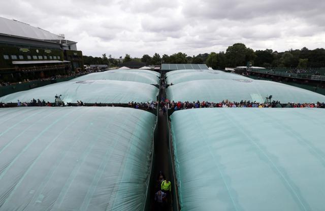 The courts are covered as rain delays play during day three of the Wimbledon Tennis Championships in London. (AP Photo) The courts are covered as rain delays play during day three of the Wimbledon Tennis Championships in London. (AP Photo)
