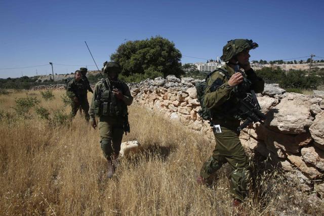 Israeli soldiers inspect the area around the Jewish settlement of Kiryat Arba. (AFP) Israeli soldiers inspect the area around the Jewish settlement of Kiryat Arba. (AFP)