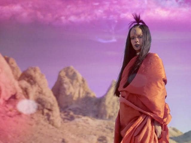 The visual spectacle features a top-knotted Rihanna dressed in an orange sari and adorned with henna on a rocky, alien planet and, towards its conclusion, transforming into a stellar entity. (YouTube) The visual spectacle features a top-knotted Rihanna dressed in an orange sari and adorned with henna on a rocky, alien planet and, towards its conclusion, transforming into a stellar entity. (YouTube)