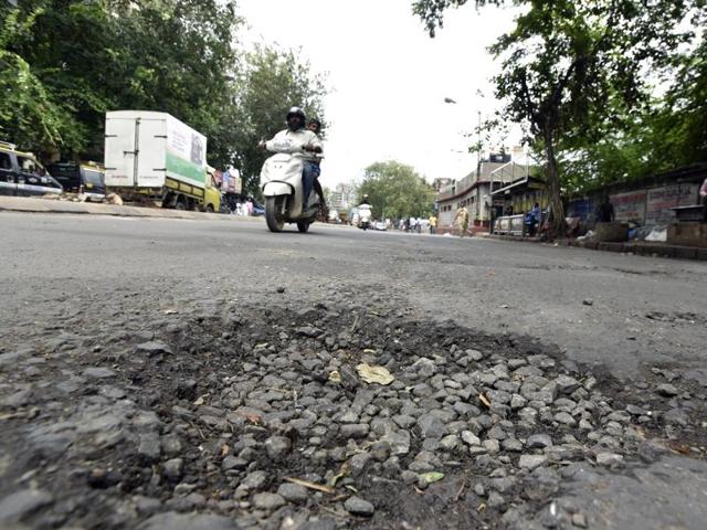Guru Tegh Bahadur station: This stretch witnesses heavy traffic throughout the day. Such potholes add to the woes of commuters, who brave the rain, traffic and congestion during peak hours, almost everyday. (Kunal Patil/ Hindustan Times)