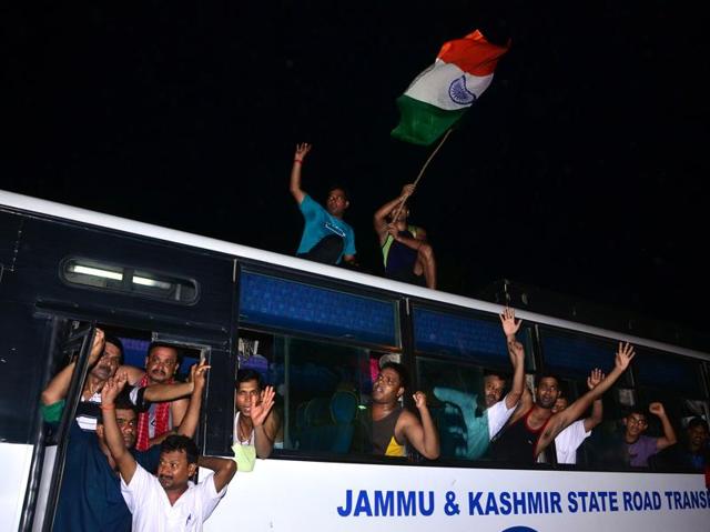 Devotees upbeat, with one of them waving the national flag atop a bus, ahead of the Amarnath Yatra, in Jammu on Friday. (Nitin Kanotra/HT Photo)