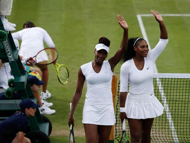 Serena Williams (right) and Venus Williams (second right) wave to the crowd after beating Slovenia's Andreja Klepac and Katarina Srebotnik during their women's doubles first-round match. (AFP Photo) 