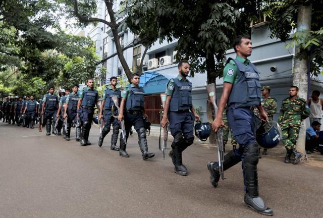 Bangladeshi policemen patrol around the site of an attack in Dhaka. (AP)