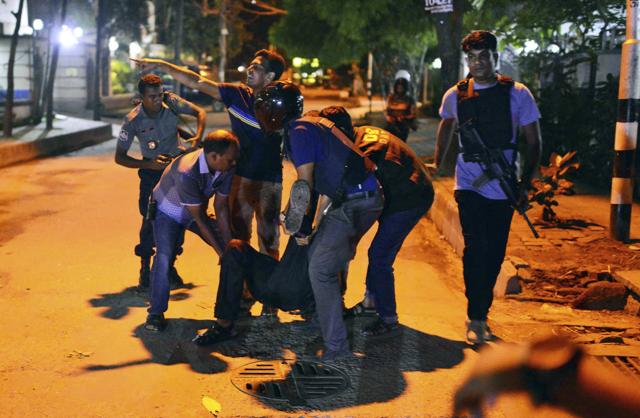 People help an unidentified injured person after a group of gunmen attacked a restaurant popular with foreigners in a diplomatic zone of the Bangladeshi capital Dhaka, Bangladesh, Friday, July 1, 2016. (AP) People help an unidentified injured person after a group of gunmen attacked a restaurant popular with foreigners in a diplomatic zone of the Bangladeshi capital Dhaka, Bangladesh, Friday, July 1, 2016. (AP)