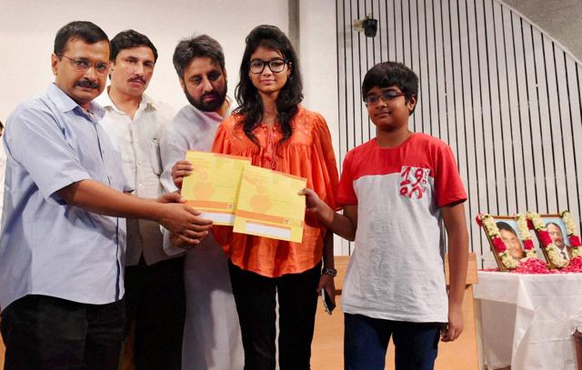 Arvind Kejriwal present a cheque to children of slain NIA officer Tanzil Ahmed. (PTI)
