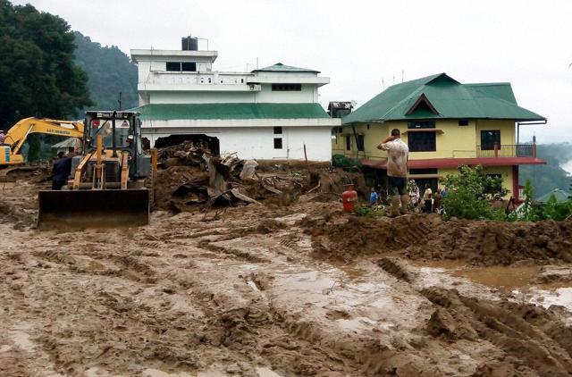 Workers busy in cleaning the debris of massive landslide that buried several houses at Bhalukpong in Arunachal Pradesh on Friday, July 1, 2016. (PTI)
