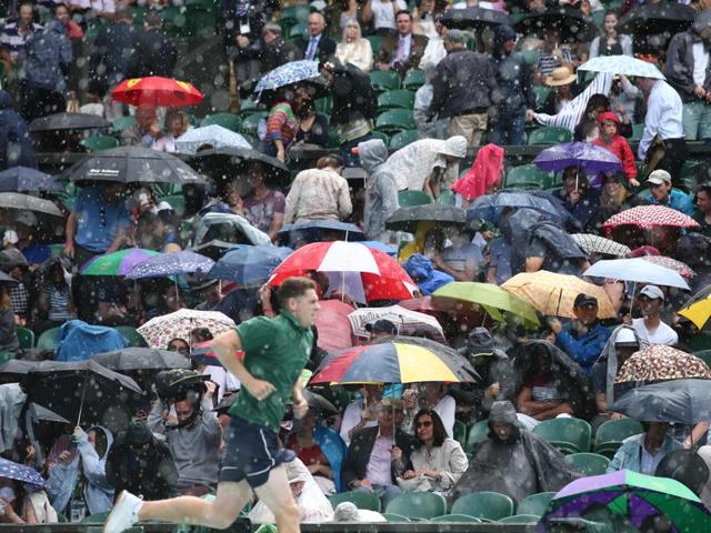 Rain falls on the spectators on centre court interrupting the match between John Millman and Andy Murray. (AFP) Rain falls on the spectators on centre court interrupting the match between John Millman and Andy Murray. (AFP)