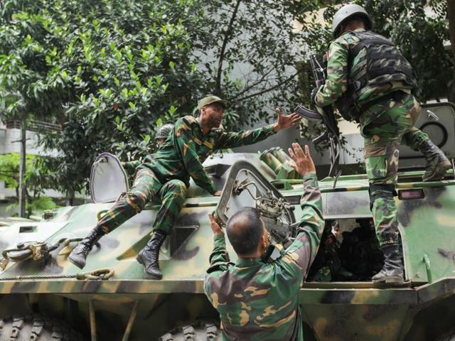 Armoured vehicles arrive after militants took hostages at a restaurant popular with foreigners in Dhaka.(AP) Armoured vehicles arrive after militants took hostages at a restaurant popular with foreigners in Dhaka.(AP)