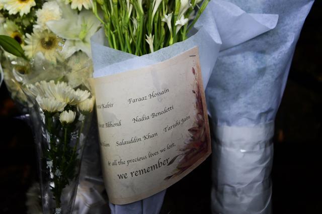 A sign bearing the names of some of the victims killed a bloody siege at an upscale cafe adorns one of many floral arrangements left near the restaurant in the Bangaldesh capital Dhaka. (AFP)