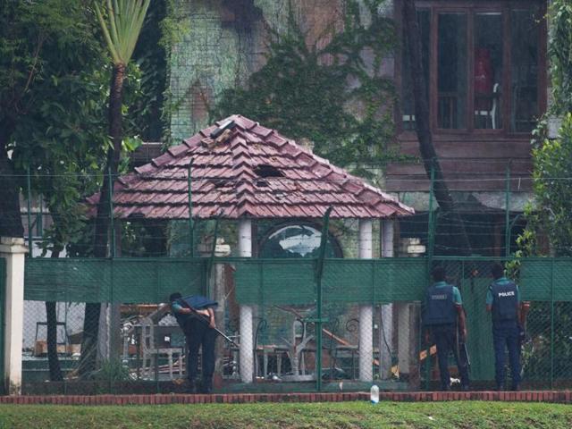 Three Bangladeshi policemen look into the back garden of the scene of the attack on Sunday, a day after a bloody siege ended with the death of 20 foreign hostages. Bangladesh began observing two days of national mourning on Sunday. (AFP)