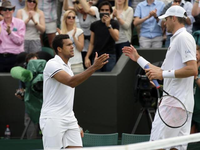 Tsonga shakes hands with Isner at the net after the match. (AP)