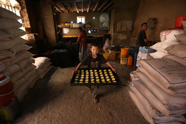 Asghar, 9, prepares sweets at a traditional factory for the upcoming Eid al-Fitr holiday to mark the end of the holy fasting month of Ramadan, in the old part of Kabul, Afghanistan, Sunday, July 3, 2016.  (AP) 