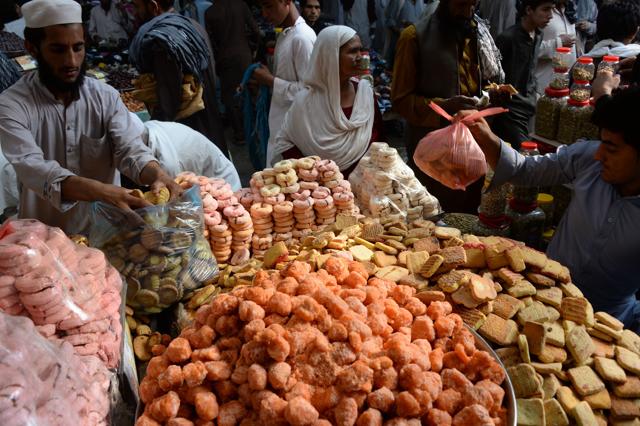 Afghan residents buy cookies for the upcoming Eid Al-Fitr festivities at a local market in Jalalabad on July 3, 2016. (AFP) 