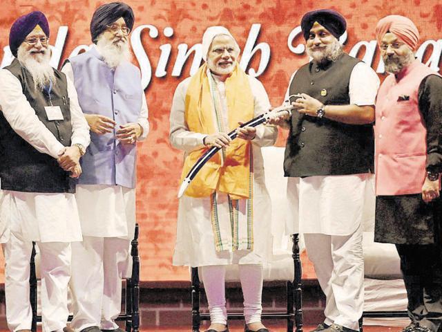 Deputy CM Sukhbir Singh Badal presenting a sword to Prime Minister Narendra Modi as CM Parkash Singh Badal looks on at the Banda Singh Bahadur martyrdom function in New Delhi on Sunday. (PTI) Deputy CM Sukhbir Singh Badal presenting a sword to Prime Minister Narendra Modi as CM Parkash Singh Badal looks on at the Banda Singh Bahadur martyrdom function in New Delhi on Sunday. (PTI)