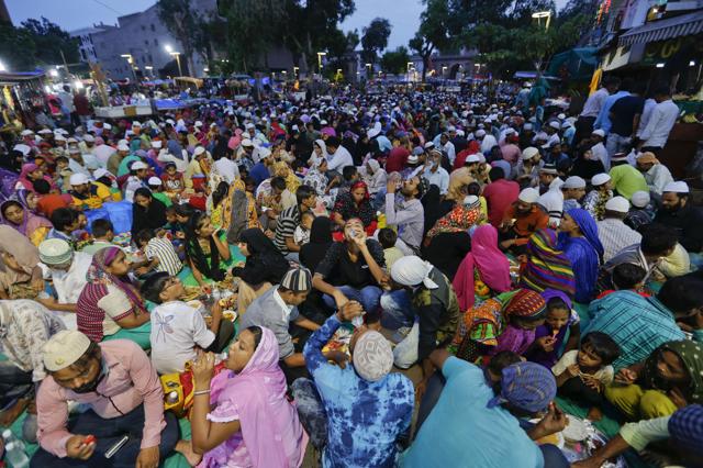 Muslims who arrived in the city for shopping on the last Sunday ahead of Eid al-Fitr, break their day long fast at a special Iftar hosted for them by traders at a market in Ahmadabad. (AP) 
