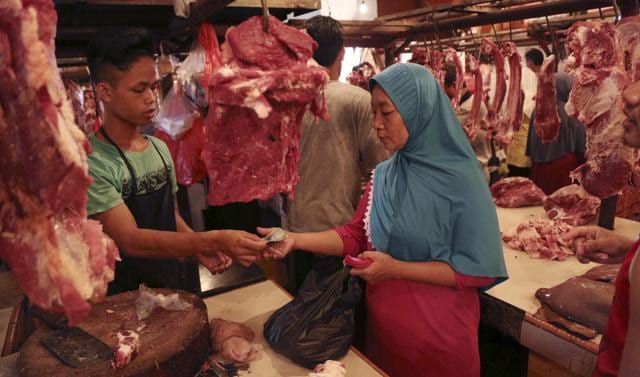 A Muslim woman shops for meat during the last few days of the holy fasting month of Ramadan at a market in Jakarta, Indonesia, Monday, July 4, 2016. (AP) 