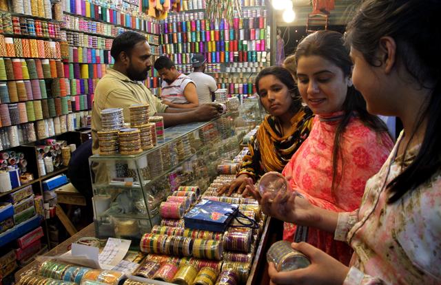 Pakistani girls buy traditional bangles for the upcoming Eid al-Fitr holiday to mark the end of the holy fasting month of Ramadan in Karachi, Pakistan. (AP) 
