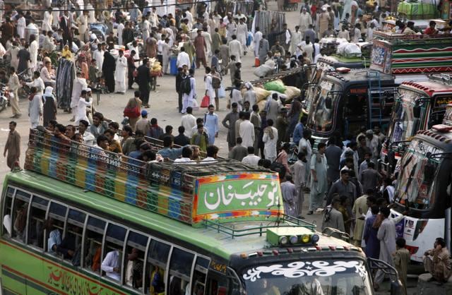 People travel on the rooftop of a passenger bus to reach their destinations for the upcoming Eid al-Fitr holiday, in Lahore, Pakistan, Sunday, July 3, 2016.  (AP) 