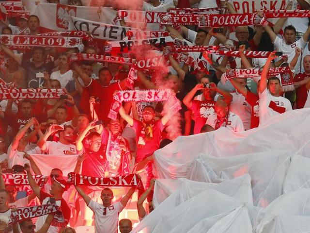 Portugal supporters cover their faces as other fans hold flares prior to the Euro 2016 quarterfinal . (AP) Portugal supporters cover their faces as other fans hold flares prior to the Euro 2016 quarterfinal . (AP)
