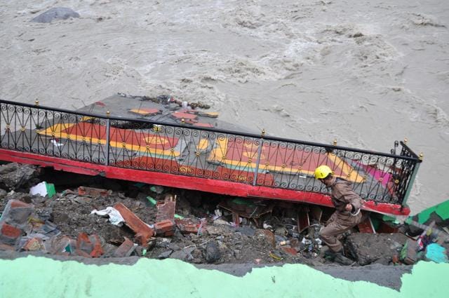 A rescue team member near a damaged house in Chamoli. (PTI) A rescue team member near a damaged house in Chamoli. (PTI)